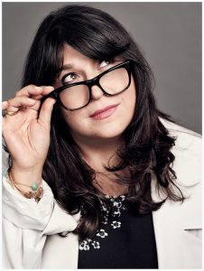 E.L James posing with her glasses and looking up.